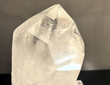 Bergkristallspitze auf schwarzem Metallständer